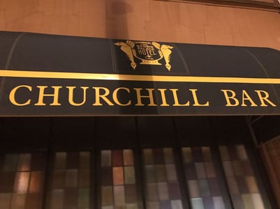 Facade of the Churchill Bar with the signage above reads, “The Brown Palace Hotel Spa and Churchill Bar