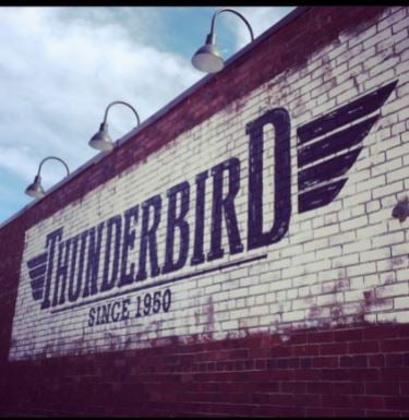 facade with the text “Thunderbird, since 1950” written on the brick red and white walls
