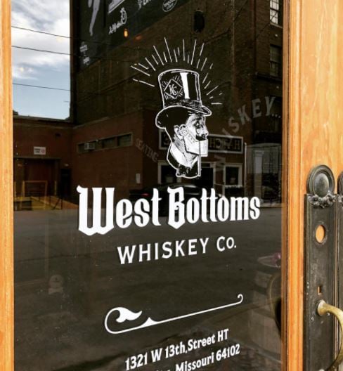  An image of West Bottoms Whiskey Co.’s glass door with the logo of the distillery on it